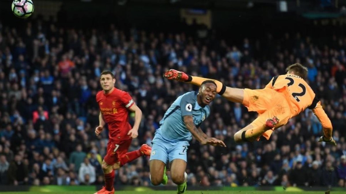 Sterling, del manchester City, choca con el portero del Liverpool Mignolet.-AFP