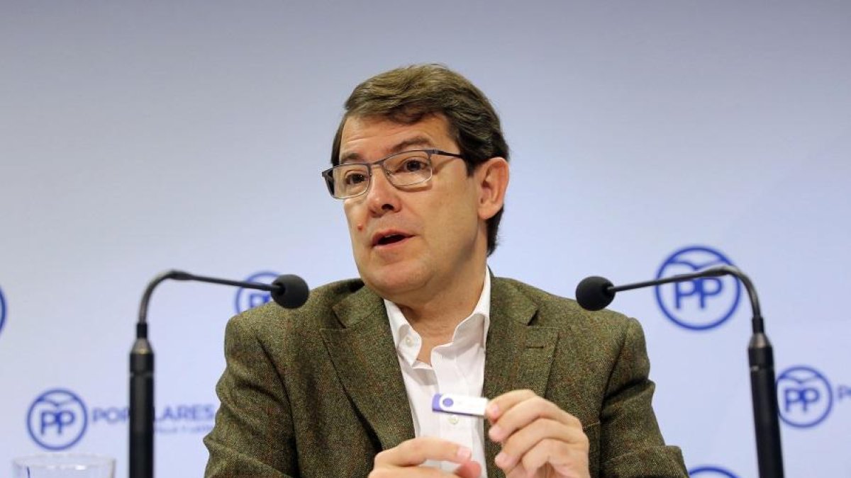 Fernández Mañueco sujeta un pendrive en el que está el programa electoral de mayo presentado ayer.-ICAL
