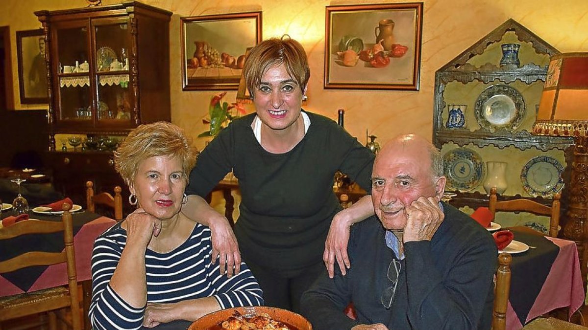 Nuria, con sus padres Zoilo y Julia, y el bacalao al ajoarriero que ha hecho célebre su restaurante.-ARGI