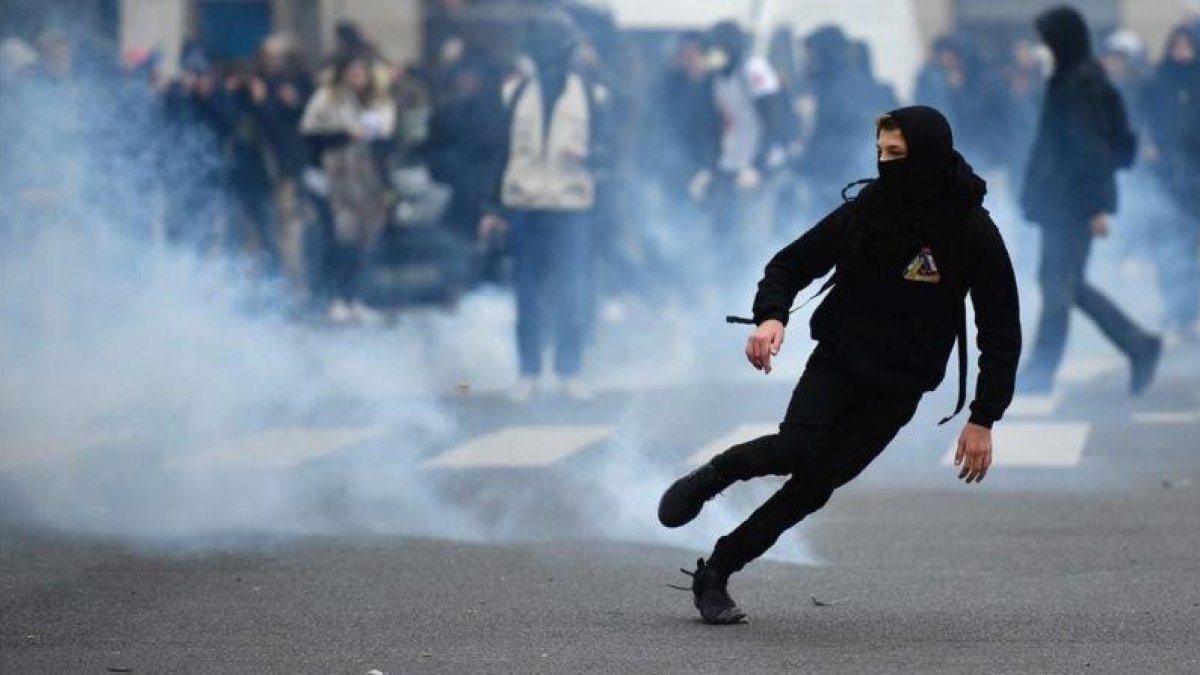 Un manifestante huye de los gases disparados por la policía.-AFP / LIONEL BONAVENTURE