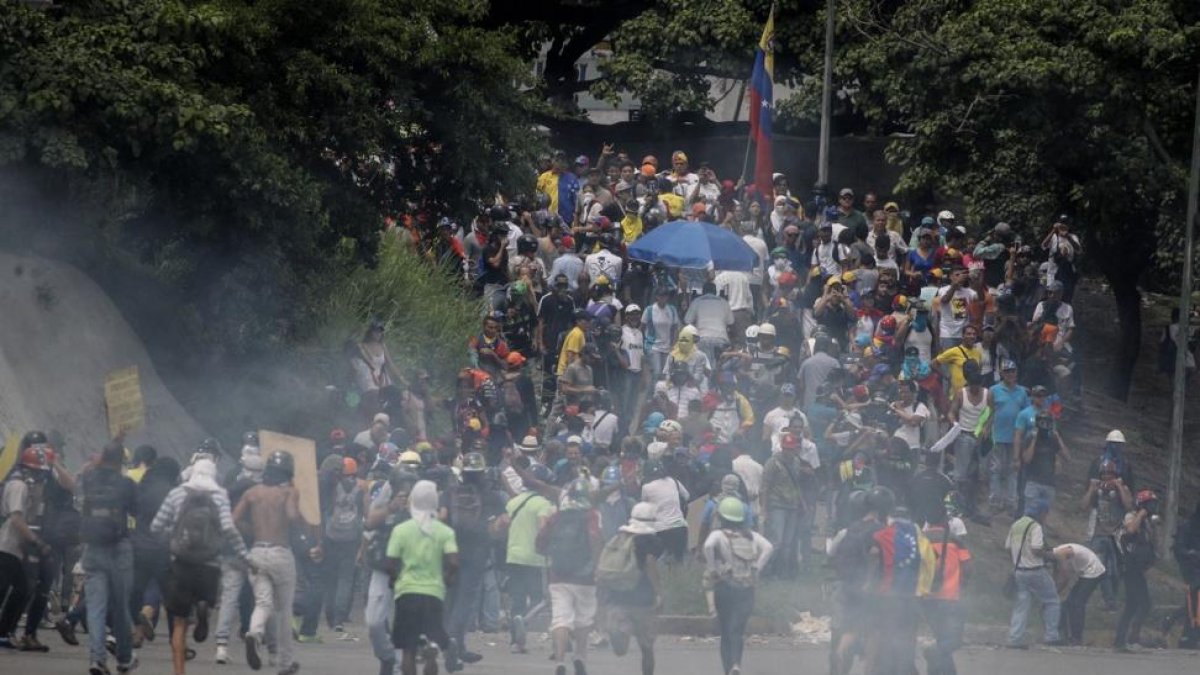 Manifestantes opositores se enfrentan a la Guardia Nacional Bolivariana (GNB) en Caracas.-MIGUEL GUTIÉRREZ (EFE)