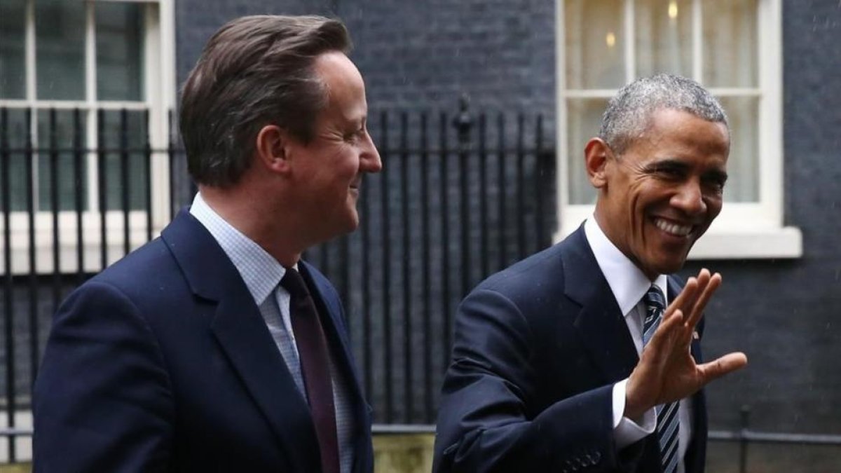 Cameron (izquierda) y Obama caminan sonrientes por el exterior de Downing Street, este viernes.-AFP / JUSTIN TALLIS
