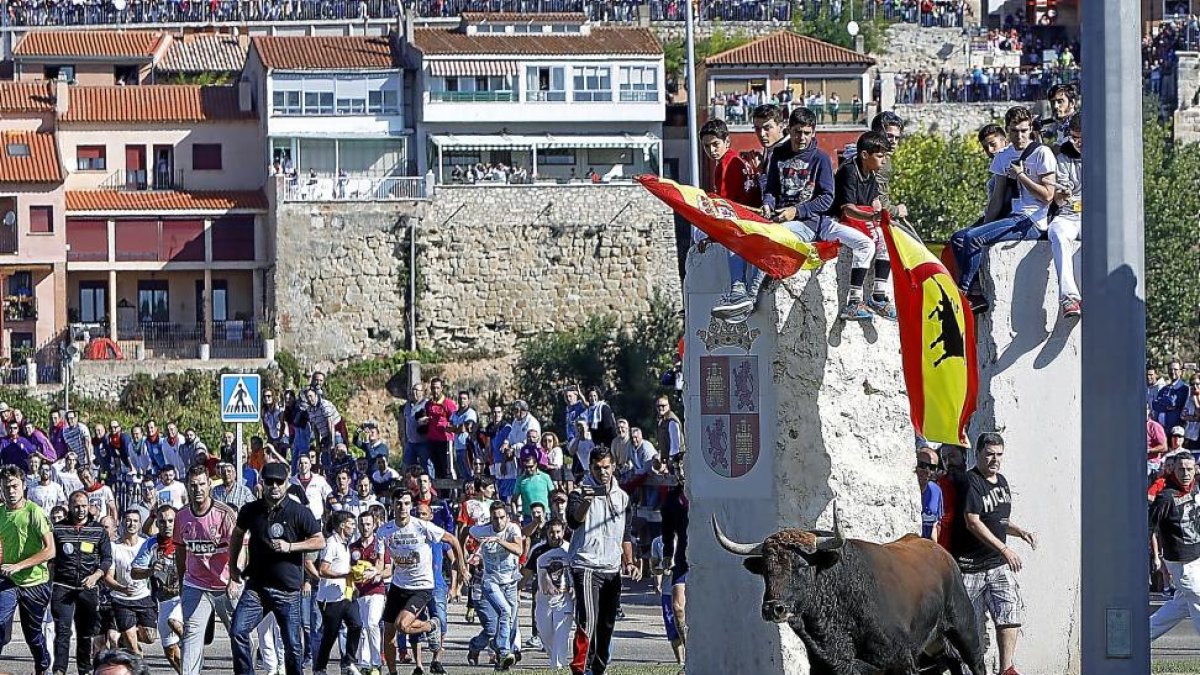 Jóvenes peñistas se apostan sobre los monolitos del recorrido del encierro.-J.M. LOSTAU