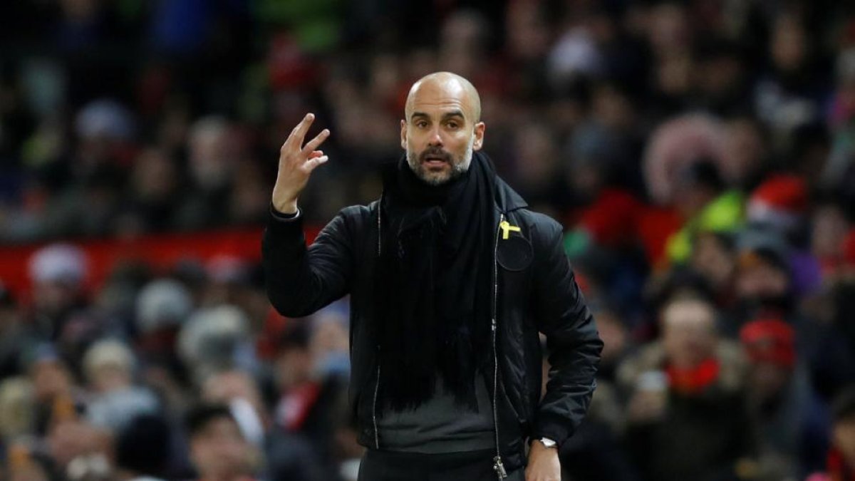 Pep Guardiola, durante el derbi de Manchester, con el lazo amarillo.-REUTERS / CARL RECINE