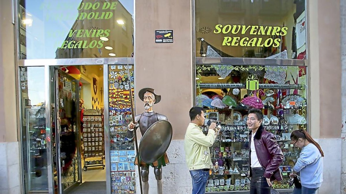 Un grupo de asiáticos realiza fotografías frente a una tienda de souvenirs durante su visita a Valladolid.-ICAL