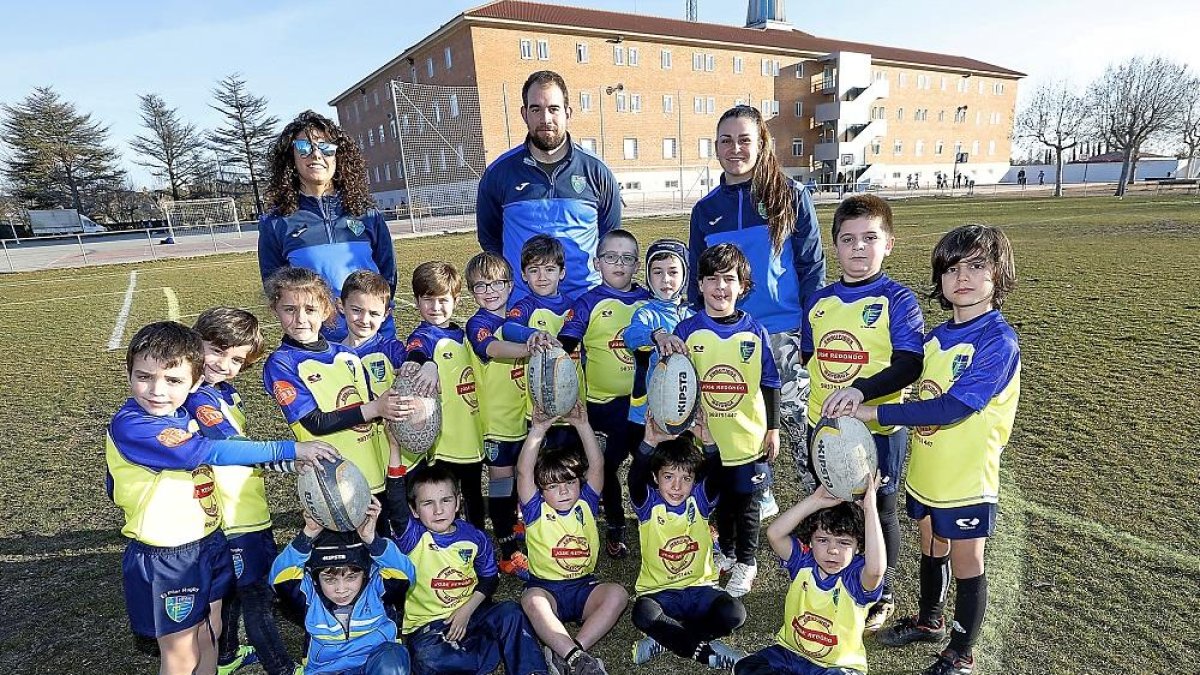 Los jugadores del equipo de rugby de El Pilar posan junto a sus entrenadores en el campo de hierba del que dispone el colegio.-J.M.LOSTAU