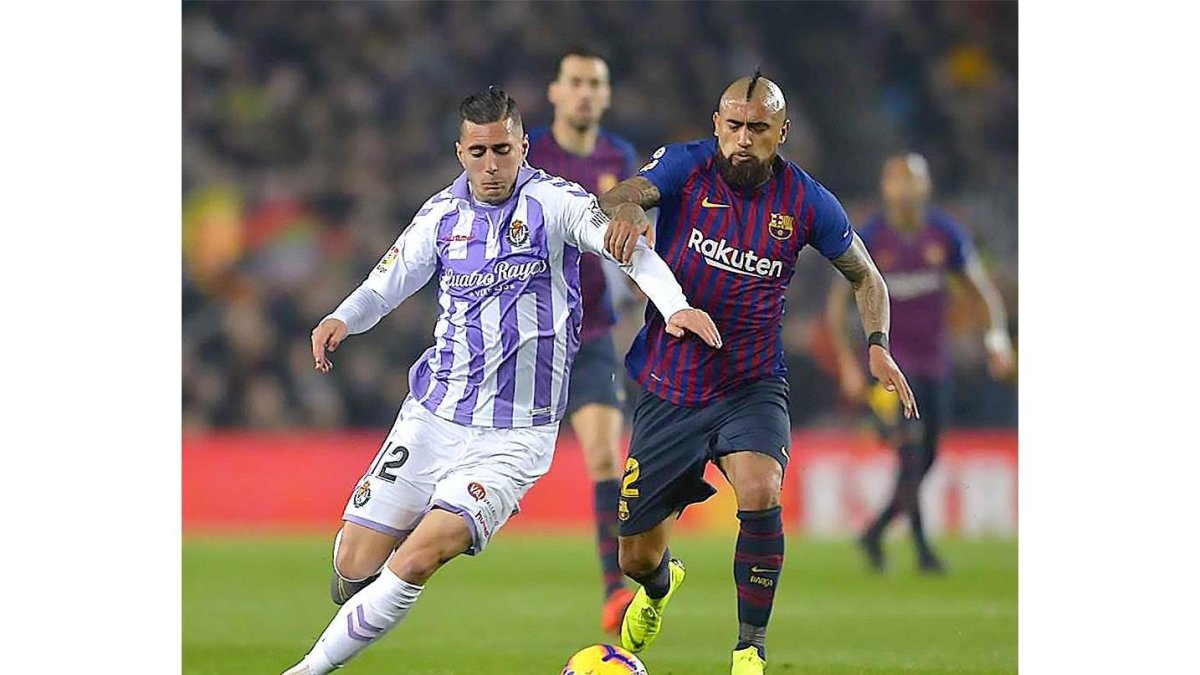 Guardiola corre tras el balón ante el marcaje de Vidal.-PHOTO-DEPORTE