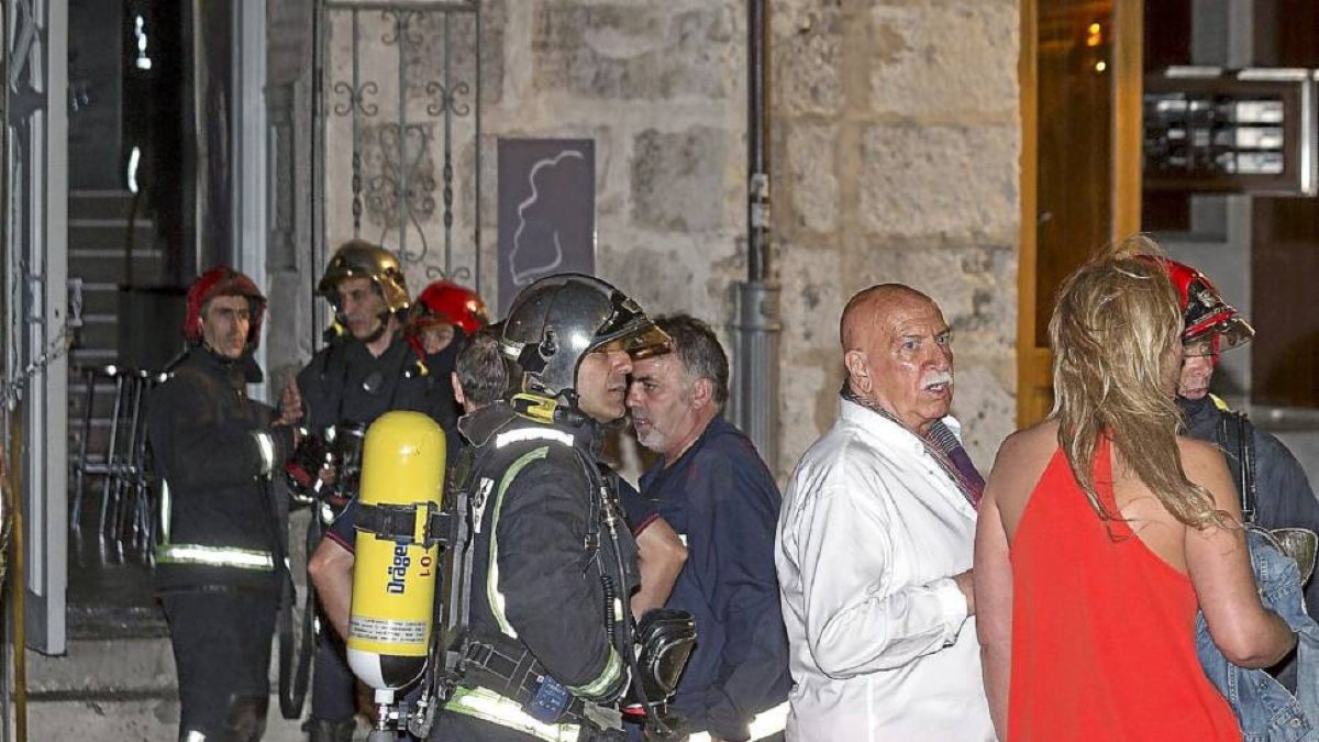 El modisto Miguel Barthe asiste a las tareas de extinción de su pub La cabeza de María Antonieta.-M.Á. Santos