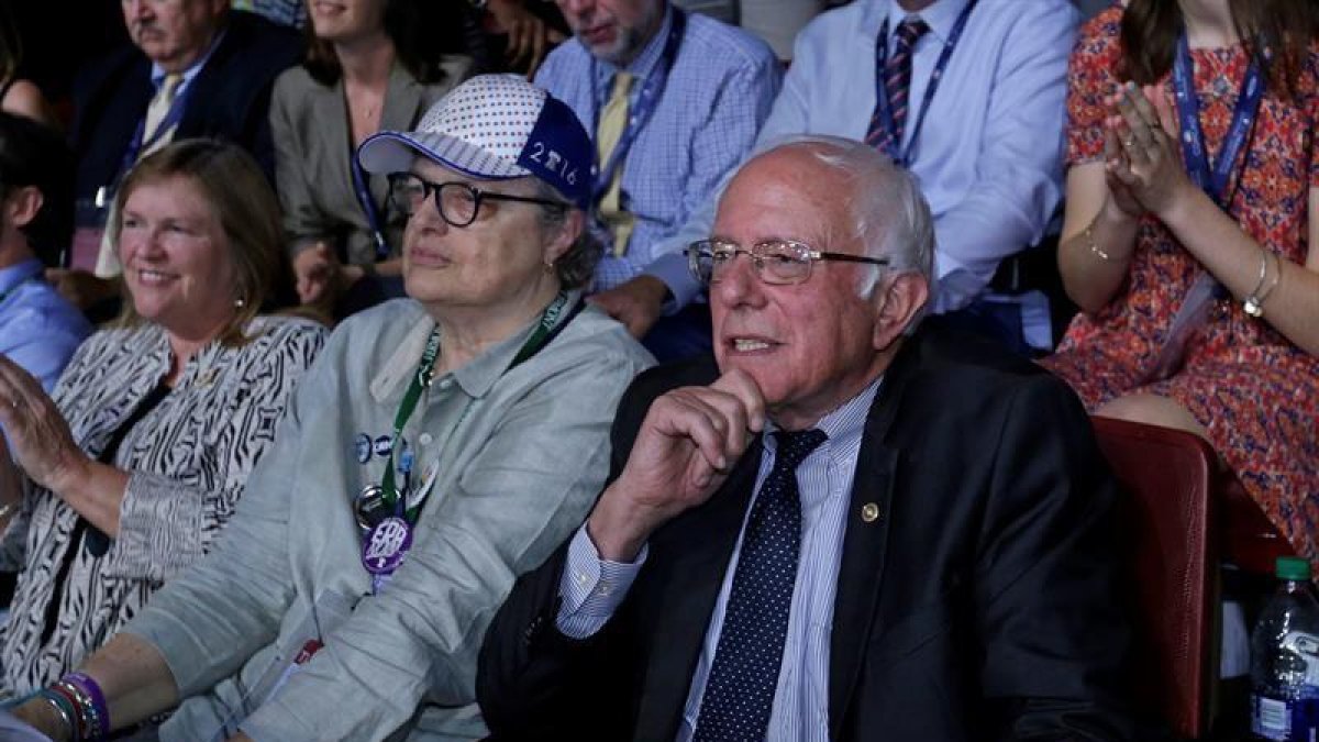 El senador estadounidense por Vermont y ex precandidato presidencial Bernie Sanders (d) y la presidenta del Partido Demócrata en Vermont Dottie Deans (c).-EFE/PETER FOLEY