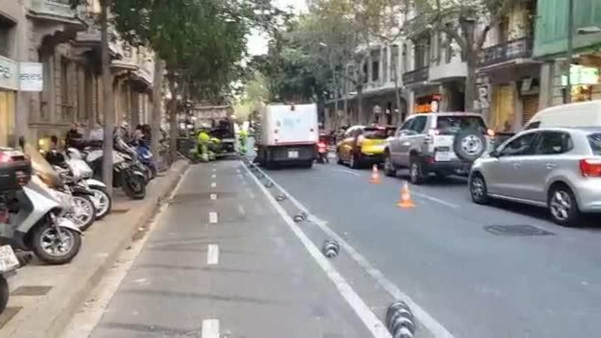 Retirada de contenedores quemados y limpieza de cera de la calzada en paseo de Gràcia con Provença.-ÓSCAR HERNÁNDEZ