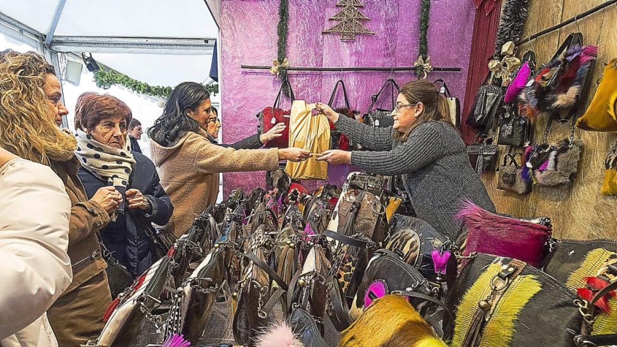 Una clienta paga su compra en un expositor de bolsos de la Feria de Artesanía.-PHOTOGENIC/ MIGUEL ÁNGEL SANTOS