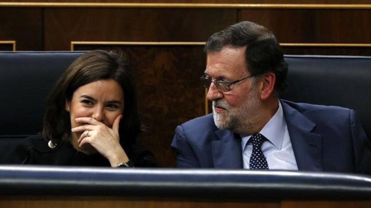 Mariano Rajoy y Soraya Sáenz de Santamaría siguen la intervención de Pedro Sánchez en el debate de investidura.-EFE / J. J. GUILLÉN