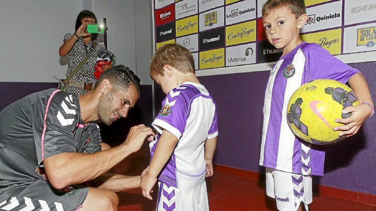 Javi Moyano firma un autógrafo a un jovencísimo aficionado del Valladolid antes de su presentación en Zorrilla.-J.M. Lostau