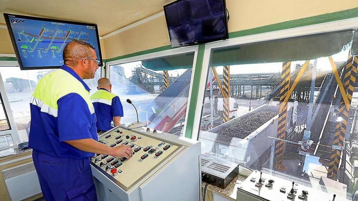 Dos operarios controlan la entrada de camiones que esperan la entrega durante la campaña de remolacha en las instalaciones de la cooperativa Acor, en la localidad vallisoletana de Olmedo.-J.M. LOSTAU