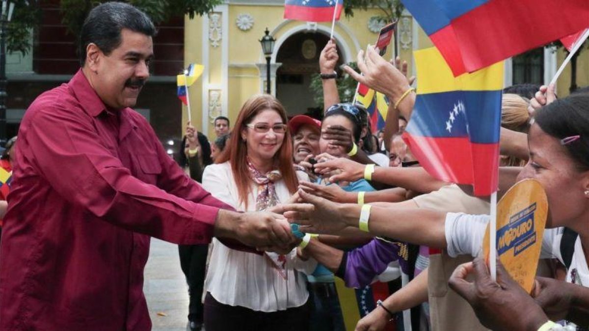 Maduro y su esposa, Cilia Flores, saludan a sus seguidores en un acto en Caracas, el 25 de enero.-EFE