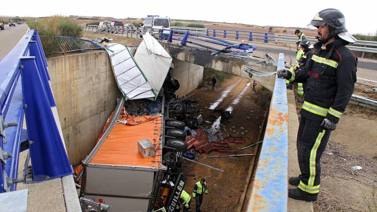 Efectivos de la Guardia Civil de Tráfico y bomberos de León trabajan en el accidente.-ICAL
