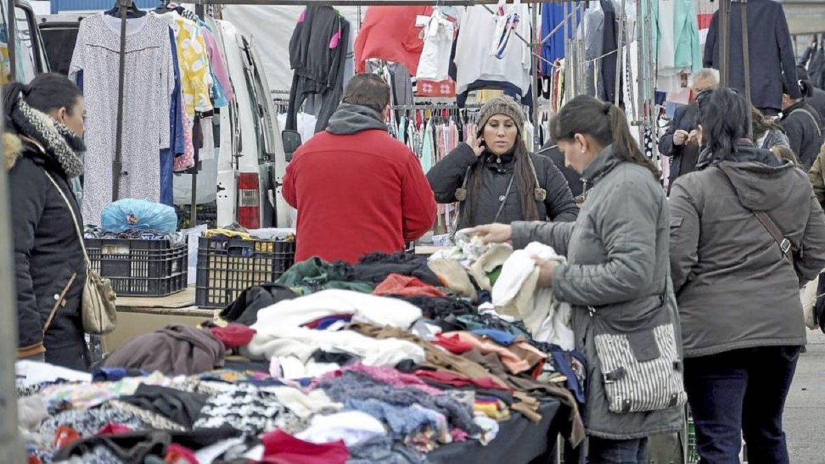 Una cliente observa diversas prendas de vestir en uno de los puestos instalados en el mercadillo medinense-Santiago G. del Campo