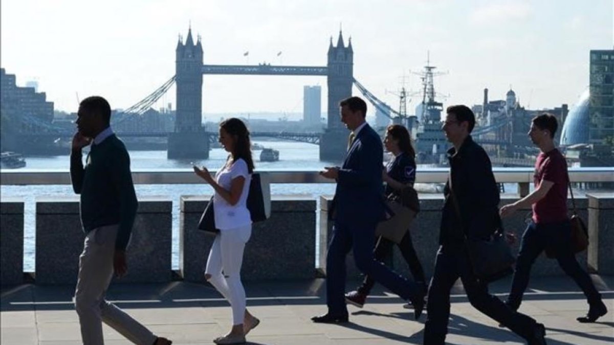 Varios transeúntes se dirigen a la City cruzando el puente de Londres, frente al puente de la Torre de Londres, el 24 de junio.-AFP / DANIEL SORABJI