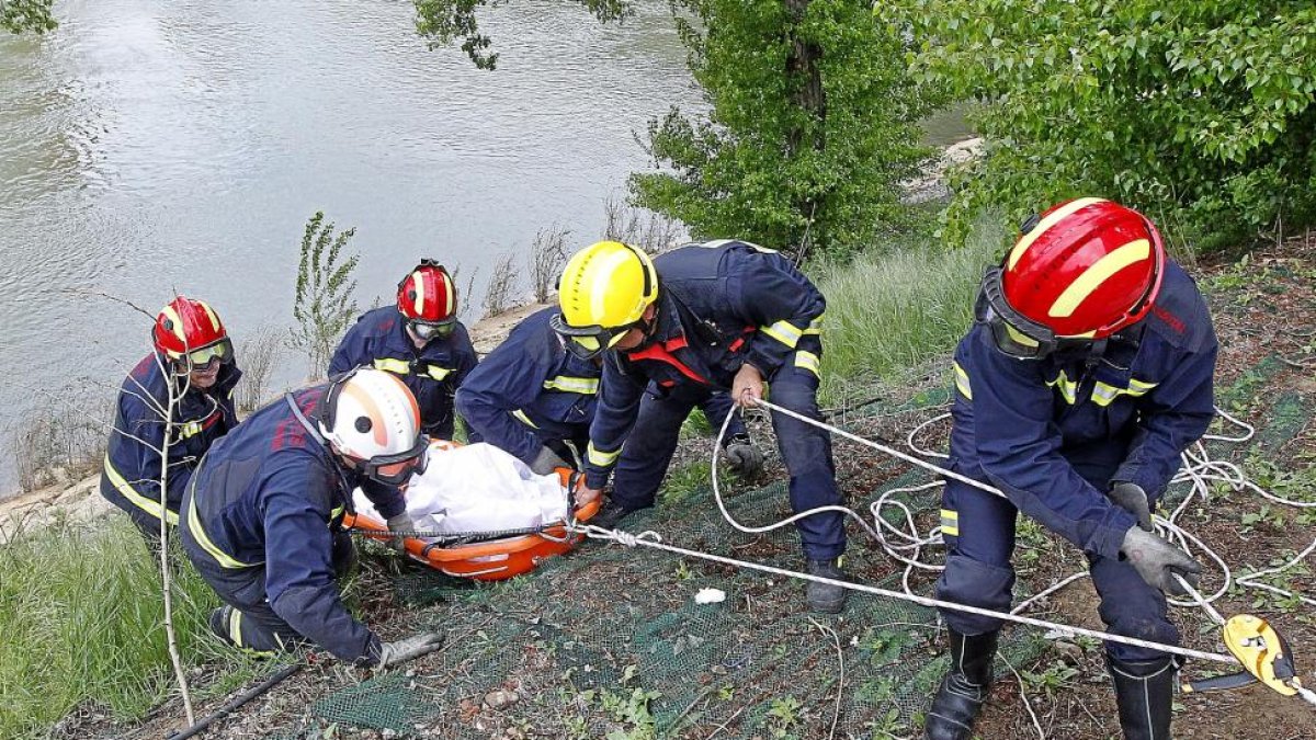 Momento en el que los Bomberos izan el cuerpo del anciano que fue rescatado del río en Arturo Eyríes.-J. M. LOSTAU