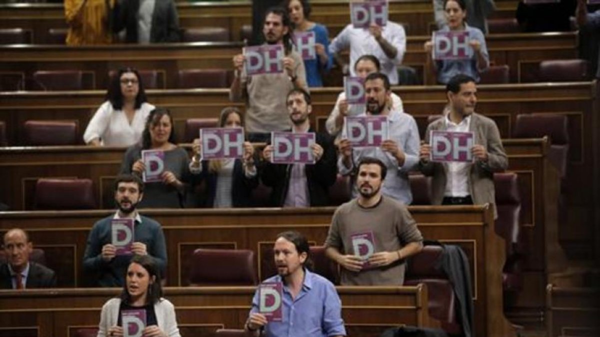 Los diputados de Podemos con octavillas, ayer.-