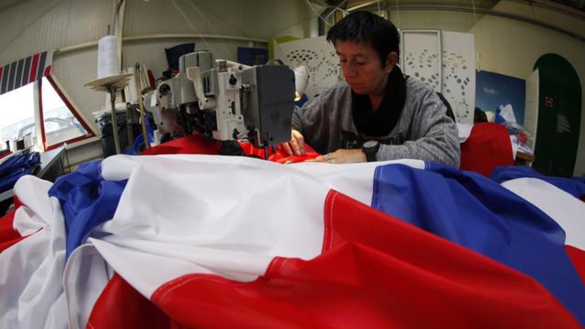 Una trabajadora de la empresa Doublet cose una bandera francesa, ayer en Lille.-AP / MICHEL SPLINGER