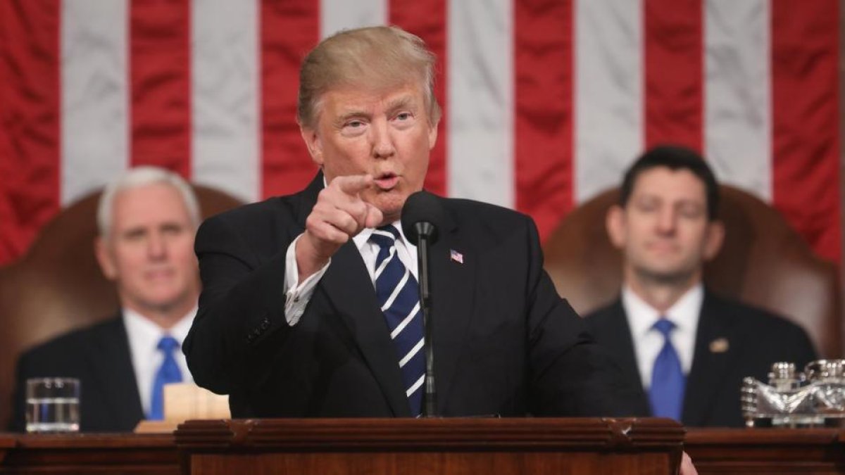 Trump, observado por el vicepresidente Pence (izquierda) y por Paul Ryan, durante su discurso al Congreso.-JIM LO SCALZO