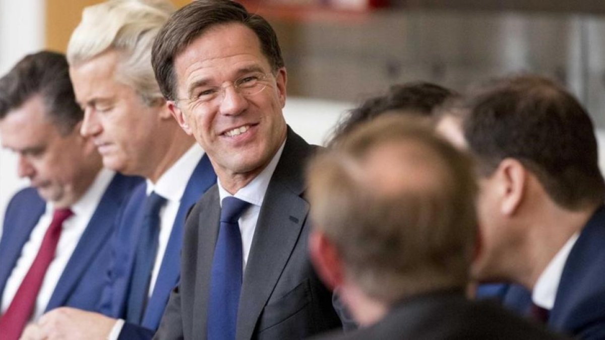 Rutte (sonriente en el centro) y Wilders (segundo izquierda), durante una reunión en La Haya, el 16 de marzo.-JERRY LAMPEN