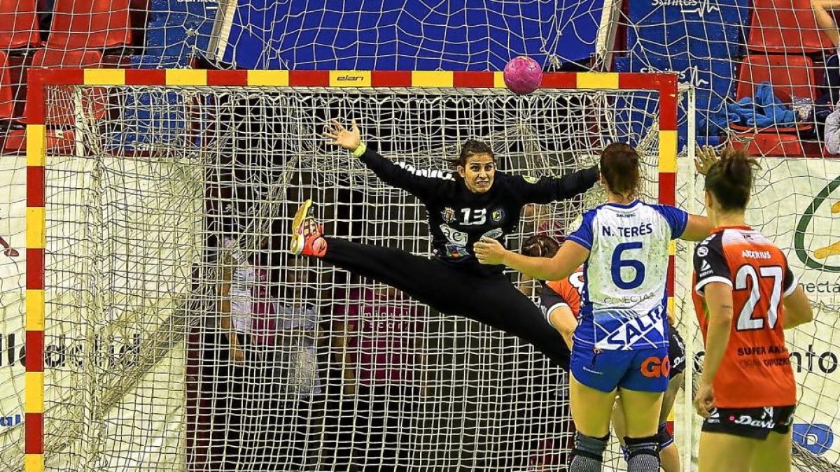 Lulu Guerra realiza un espectacular salto para intentar evitar un gol guipuzcoano ante la mirada de Nekane Terés y Silvia Arderius.-MIGUEL ÁNGEL SANTOS