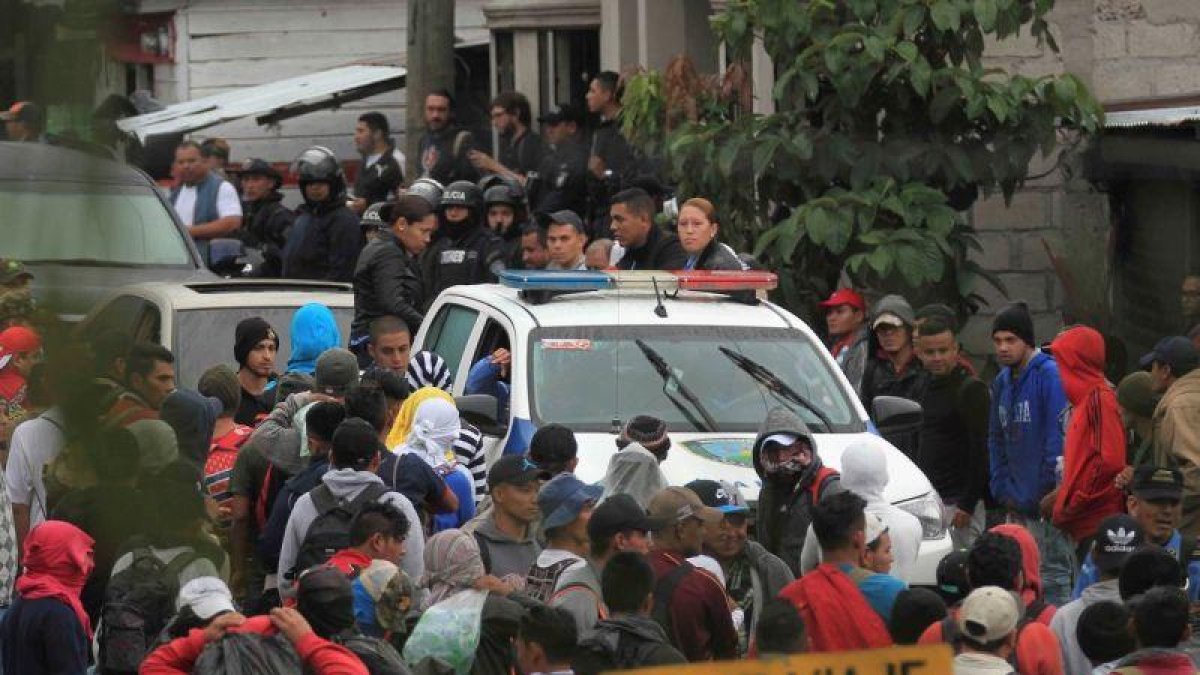 Migrantes hondureños hacen fila en un control policial donde se les verifica sus antecedentes penales y si tienen alguna orden de captura.-EFE