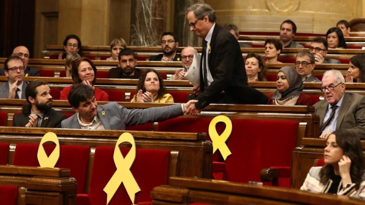 Quim Torra saluda a Sergi Sabrià durante una sesión del Parlament.-/ ELISENDA PONS