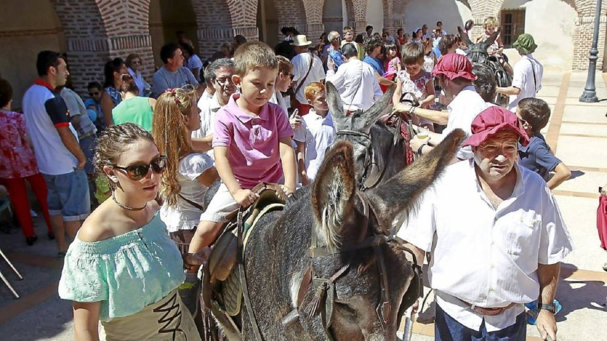 Un niño disfruta de un paseo en burro en el recinto donde estaban ubicados diferentes expositores que recreaban oficios barrocos.-J. M. Lostau