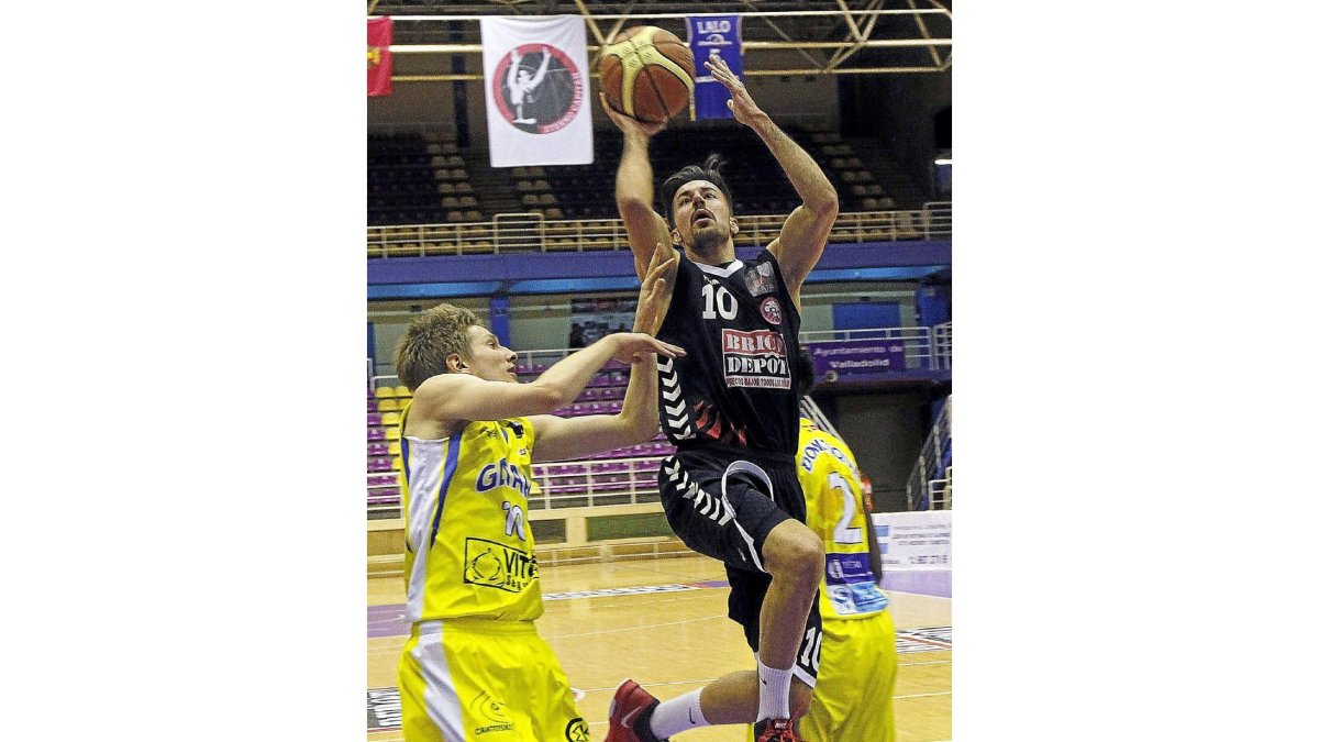 Antonio Izquierdo (dorsal 10) penetra para lanzar a canasta entre dos jugadores del Getafe.-J. M. LOSTAU