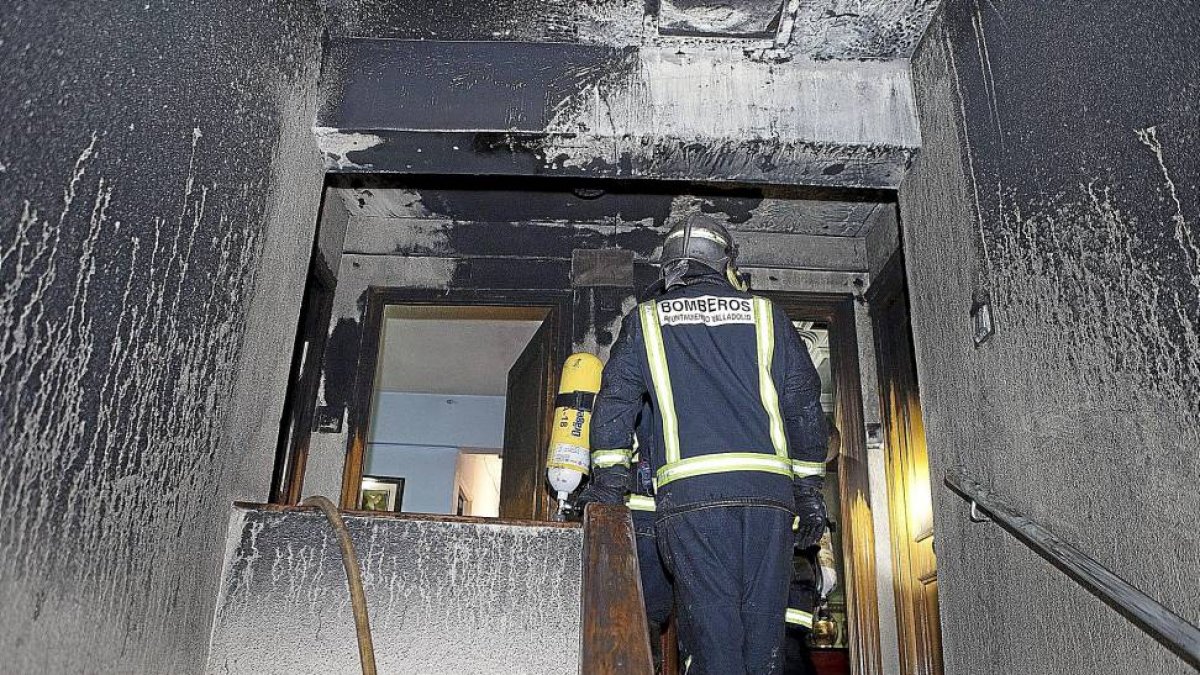 Los bomberos acceden a la vivienda donde se registró el incendio.-J.C. Castillo