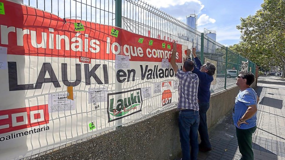 Los trabajadores de Lauki cuelgan una pancarta en el último día de trabajo de la fábrica.-PABLO REQUEJO