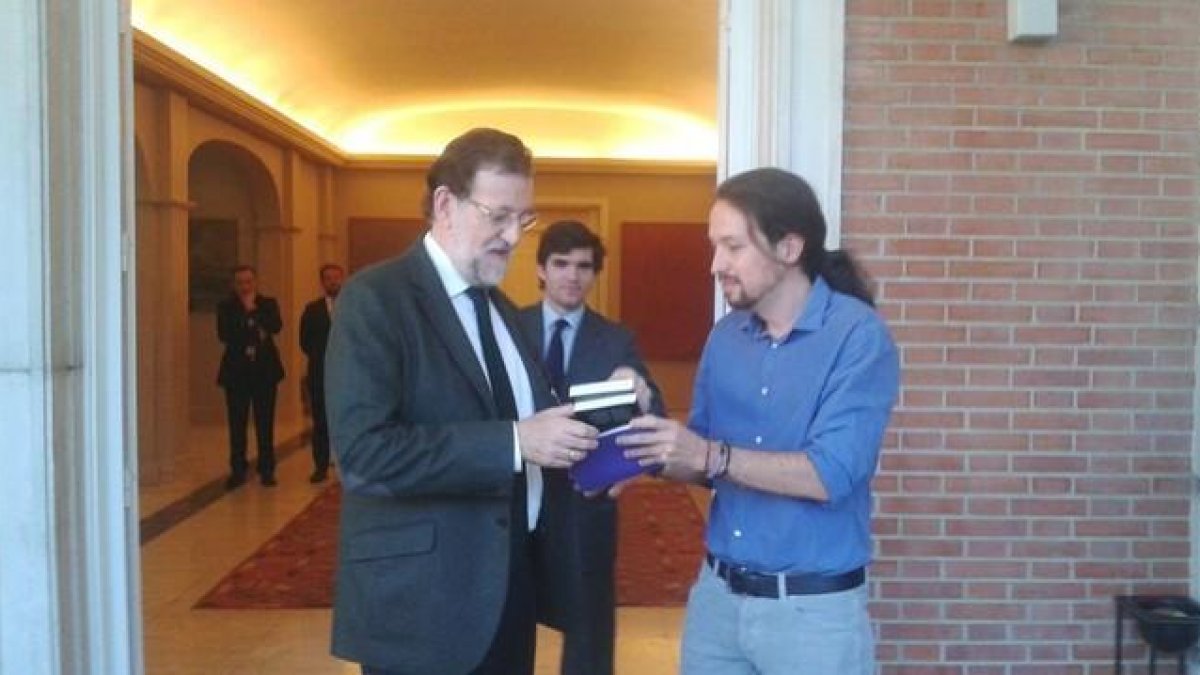 En el primer encuentro entre los dos líderes, el candidato a las presidenciales de Podemos le entrega un libro de Machado a Mariano Rajoy-Podemos