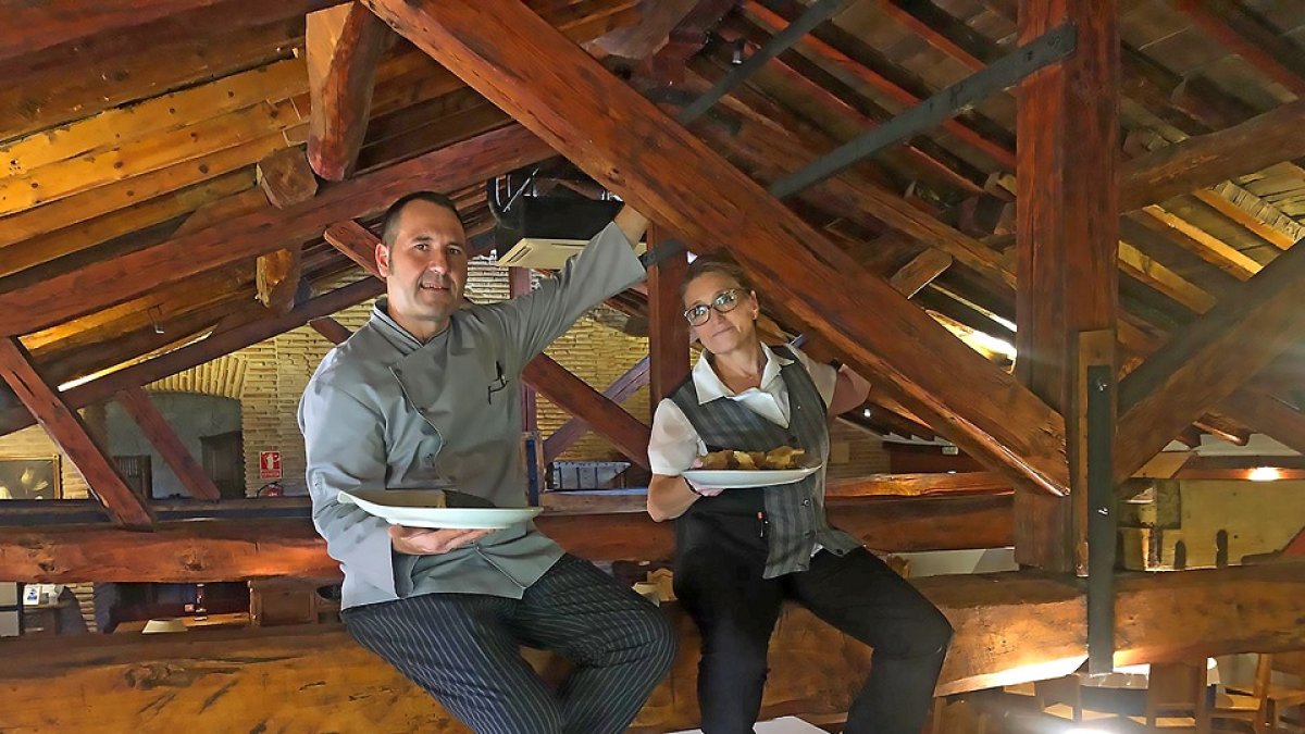 Iñaki García y Mercedes Perrino, sobre una de las vigas de su restaurante en el Real Monasterio de San Zoilo.  / ARGICOMUNICACIÓN