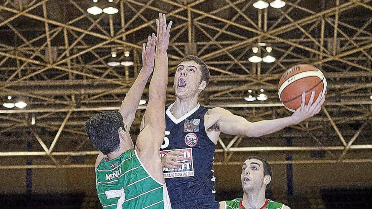 El recién incorporado Pablo Pérez intenta de forma acrobática una canasta ante la oposición de Mendía.-J.C. Castillo