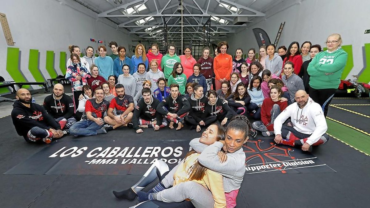 Dos de las alumnas del seminario de grappling enfocado a la defensa personal de las mujeres realizan una llave ante la mirada de sus compañeros.-J.M. LOSTAU