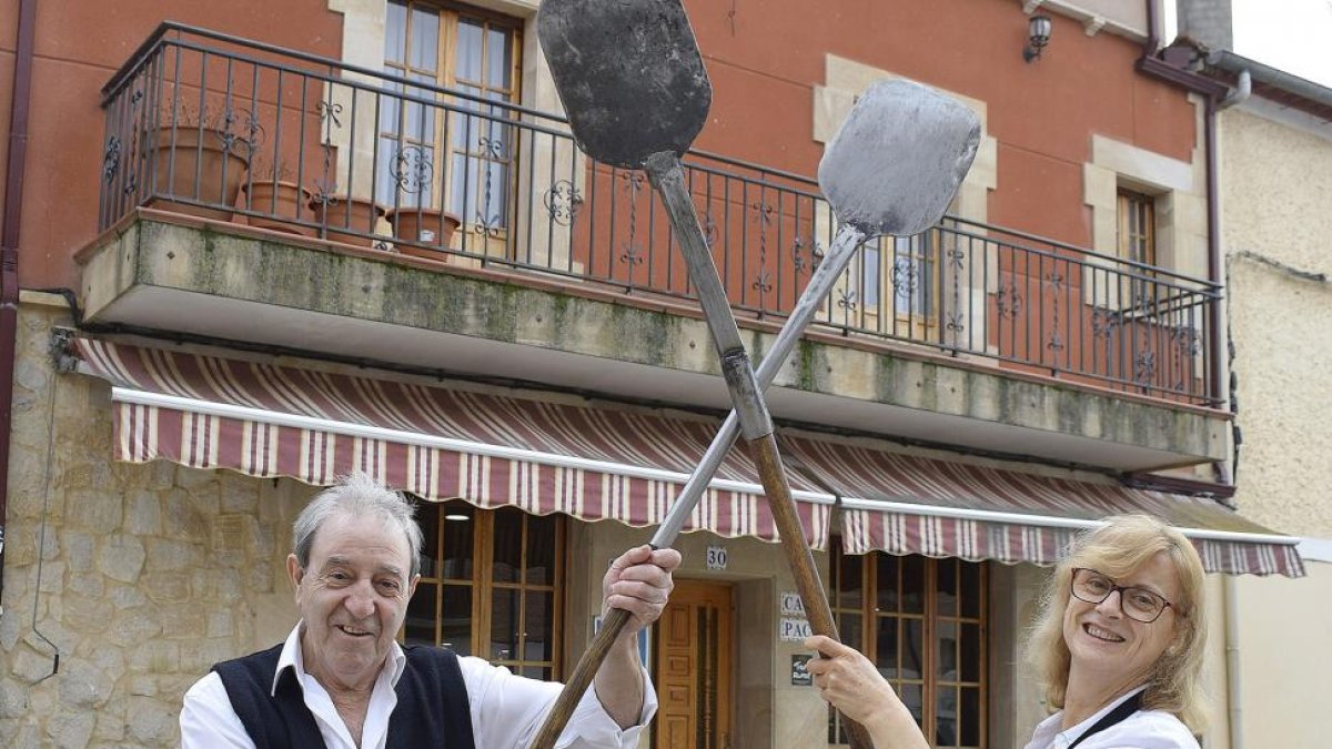 Paco e Isabel, con las palas del horno de leña, en el exterior de su bar restaurante.-ARGICOMUNICACIÓN
