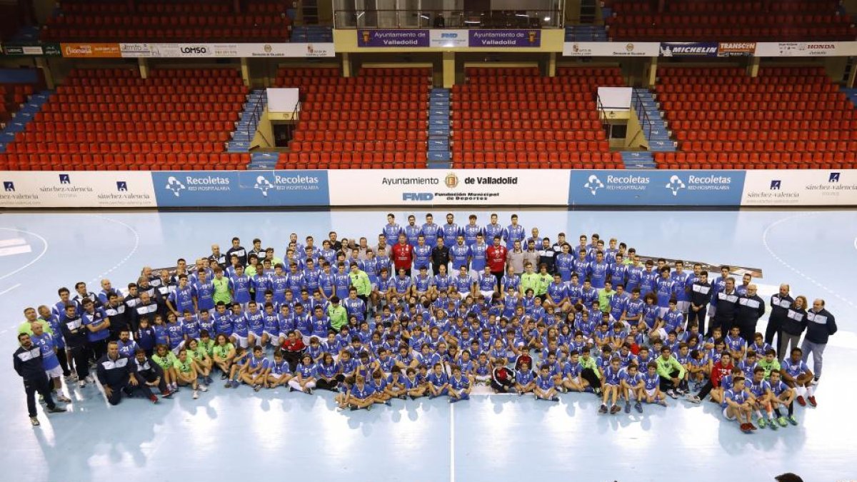 Entrenadores, ayudantes y jugadores de todas las categorías del Recoletas AtléticoValladolid posan sobre el parqué de Huerta del Rey.-J. M. LOSTAU