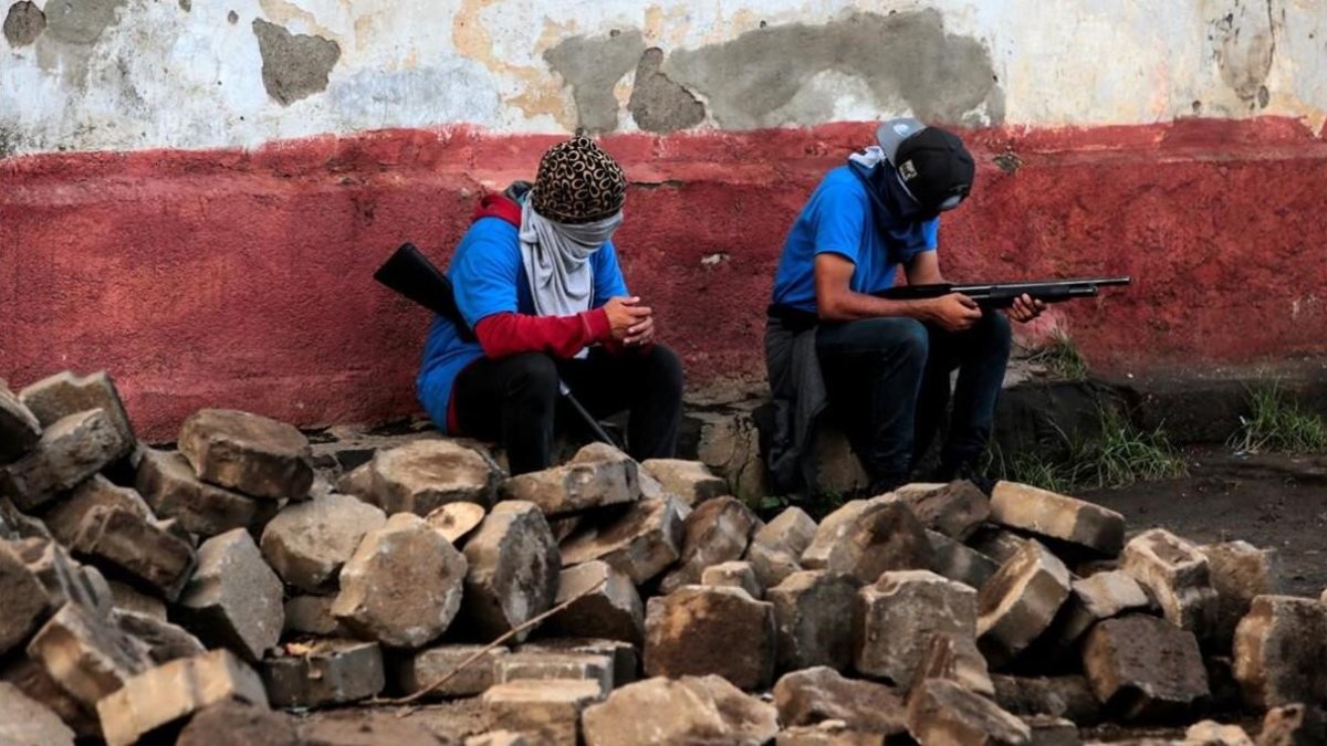 Miembros de las fuerzas gubernamentales sentados sobre lo que queda de las barricadas destruidas en el barrio de Monimbo  /-OSWALDO RIVAS (REUTERS)