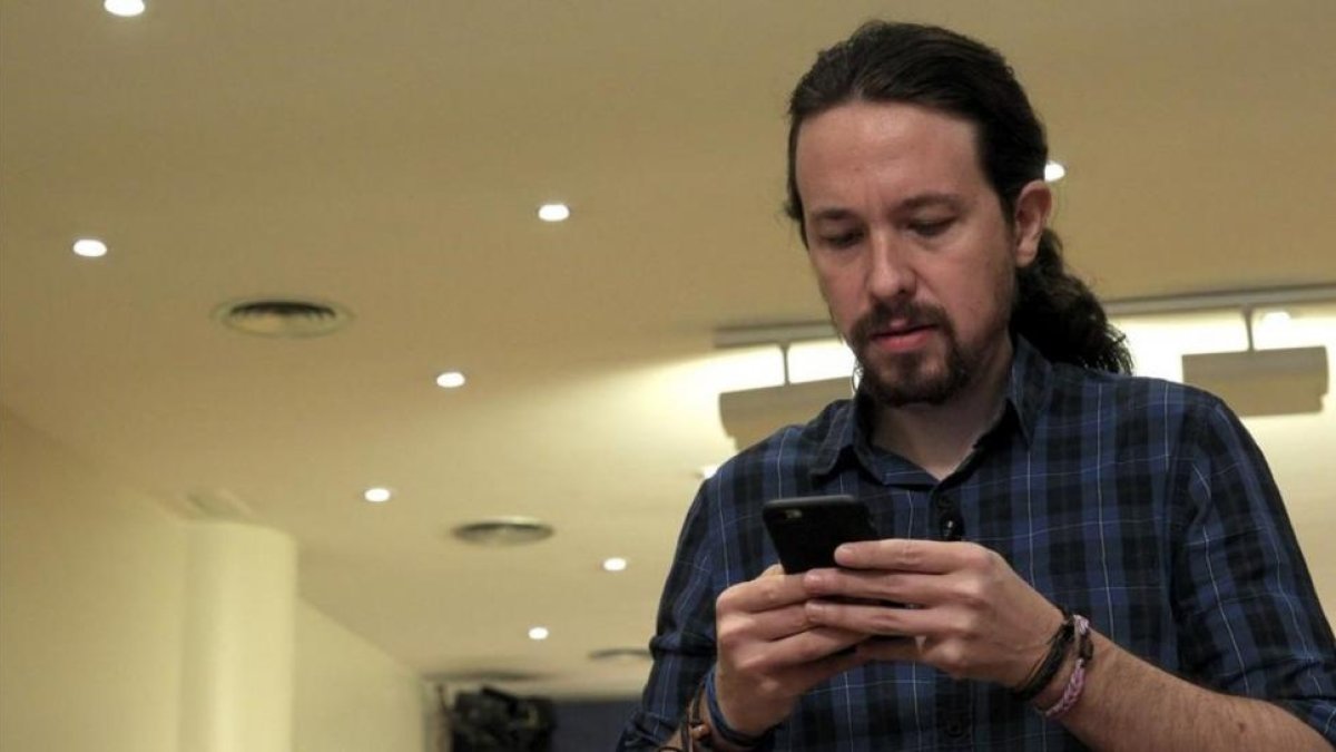 El secretario general de Podemos, Pablo Iglesias, mira su móvil antes de comparecer ante los medios, este jueves.-EFE / CHEMA MOYA