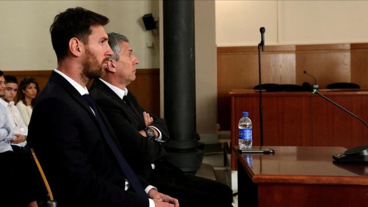 Messi y Jorge, su padre, durante el juicio en Barcelona.-
