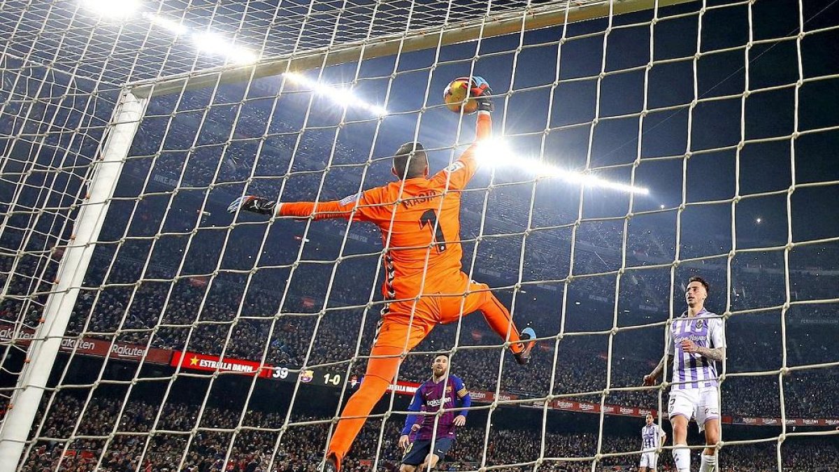 Masip detiene a una mano el rechazo de cabeza de Messi, tras fallar éste un penalti, ante la mirada de Calero y Nacho.-ALBERT GEA / REUTERS