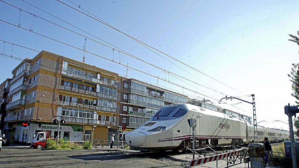 Un tren pasa por el paso a nivel de La Pilarica, junto a la calle Nueva del Carmen-Ical
