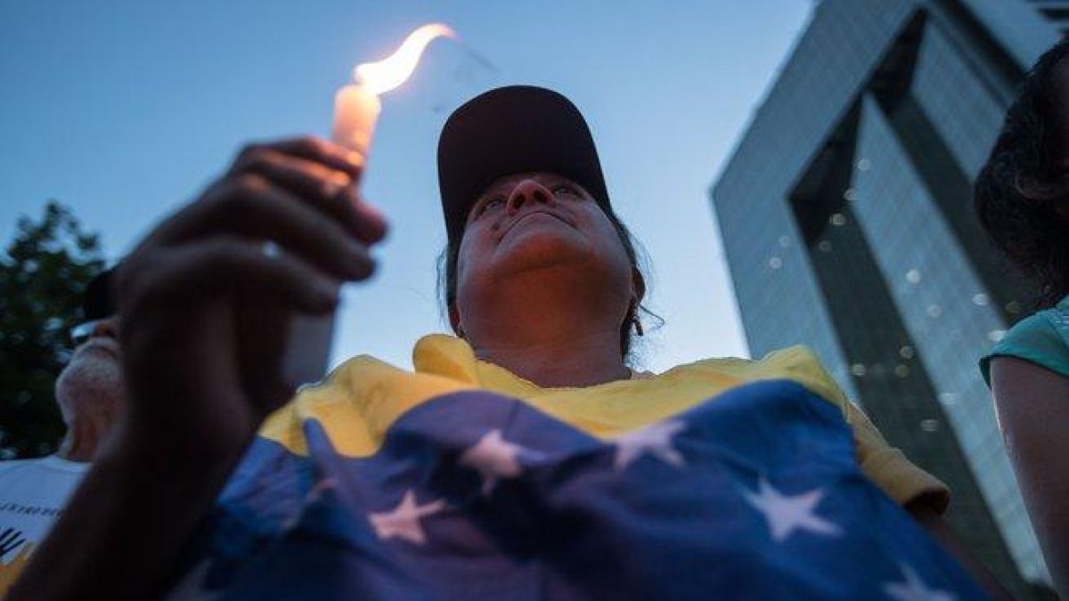 Las personas protestas en Venezuela con veladoras.-EFE