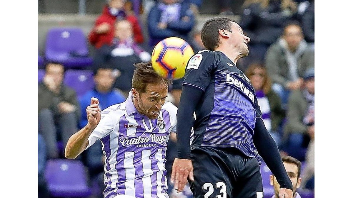 Míchel se lleva un balón de cabeza, en pugna aérea con el leganesista Vesga.-J.M. LOSTAU
