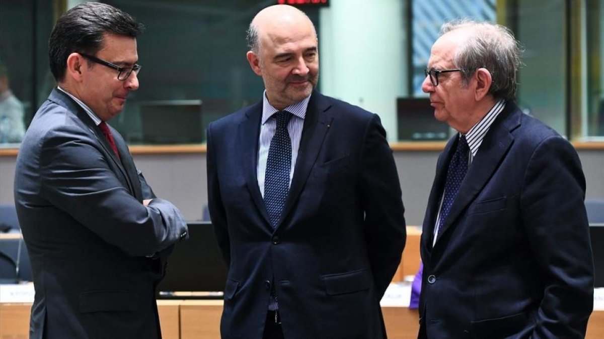 El ministro de Economía italiano, Pier Carlo Padoan (derecha), su homólogo español, Román Escolano (izq) y el comisario europeo Pierre Moscovici, antes de la reunión del Eurogrupo, el 12 de marzo.-/ AFP / EMMANUEL DUNAND