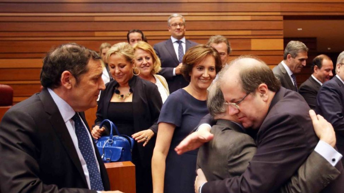 Juan Vicente Herrera abraza al consejero de Economía, Tomás Villanueva, en presencia de Josefa García Cirac y Antonio Sáez tras el pleno de investidura del candidato a la Presidencia de la Junta de Castilla y León-ICAL