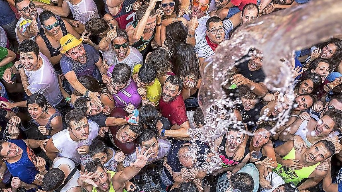 Una multitud de peñistas recibe un baño de agua durante la celebración del chúndara en Peñafiel.-J.M. LOSTAU